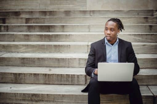 man with laptop on stairs
